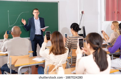 Positive male lecturer explaining new theme at adult education class - Shutterstock ID 1887024280