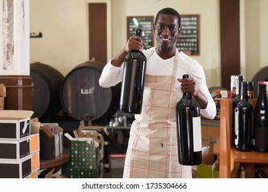 
Positive Male Seller Recommends Two Large Bottles Of Wine For Purchase At A Wine House
