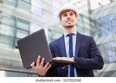 Positive man engineer talking  work at the laptop outdoors - Shutterstock ID 1527032558