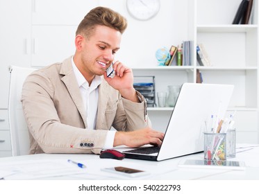 Positive man having mobile conversation in modern office