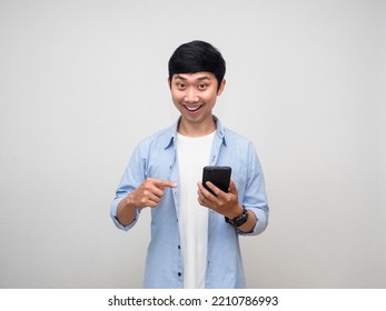 Positive Man Point Finger At Mobile Phone With Gentle Smile Isolated