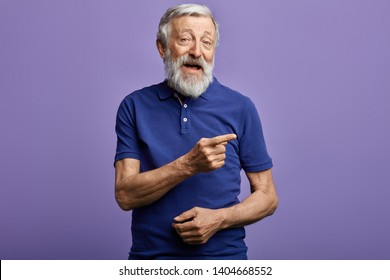 Positive Man Pointing With Hand And Finger To The Side. Look Here, Happy Old Man Showing Direction, Pension Is Being Given Here. This Is The Right Way.