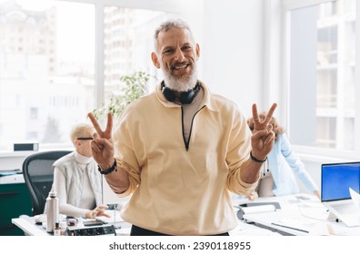 Positive man showing peace sign in office