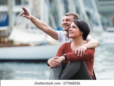 positive mature couple hugging outdoors at sunny spring day