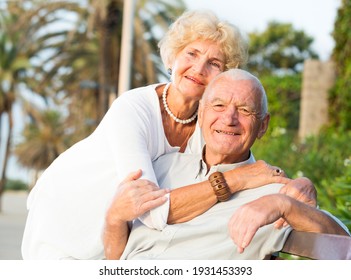 positive mature couple of male and female sitting on bench