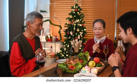 Positive Mature Man Praying, Saying Grace Before Holiday Dinner. Christmas, New Year, Thanksgiving And Celebration Concept