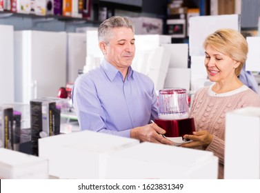 Positive Mature Married Couple In Shopping Center Buys Small Kitchen Household Appliances For Their Home