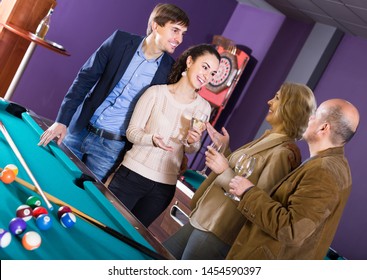 Positive  Mature And Young Couples Hanging Out In Billiard Club Together