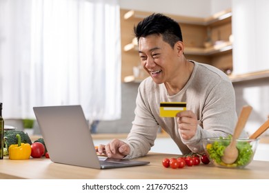 Positive Middle Aged Chinese Man Buying Food Online, Using Brand New Computer And Plastic Credit Card, Purchasing Ingredients For Healthy Dinner, Cooking For Family At Home, Copy Space