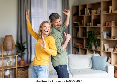 Positive Middle Aged Couple Dancing In Living Room Interior, Romantic African American Spouses Having Fun Together And Laughing, Mature Husband And Wife Enjoying Spending Time At Home, Copy Space - Powered by Shutterstock