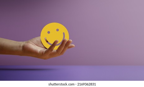 Positive Mind, Enjoying Life Concept. Hand Holding a Smiling Face Paper. Sign of Mental Health, Wellbeing  and Healthy Lifestyles. Happy Client giving Positive Review and Feedback - Shutterstock ID 2169362831