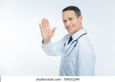 Positive Minded Mature Doctor Waving Hello Over Background