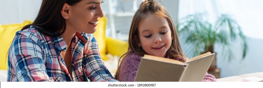 Positive Mother And Daughter Reading Book At Home On Blurred Background, Banner