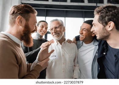 Positive multiethnic group hugging middle aged man during alcoholics meeting in rehab - Powered by Shutterstock