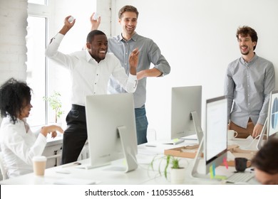 Positive multiracial team having fun together, laughing and throwing paper balls, diverse colleagues enjoy spending work break, playing childish at workplace. Concept of teambuilding, good relations - Powered by Shutterstock