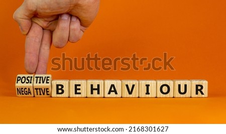 Positive or negative behaviour symbol. Businessman turns cubes, changes words negative behaviour to positive behaviour. Orange background, copy space. Business, positive or negative behaviour concept.