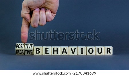 Positive or negative behaviour symbol. Businessman turns cubes, changes words negative behaviour to positive behaviour. Grey background, copy space. Business, positive or negative behaviour concept.