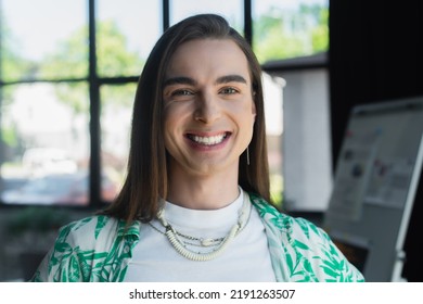 Positive Nonbinary Person Looking At Camera In Office