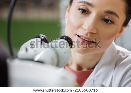 positive optometrist working with vision screener on blurred foreground