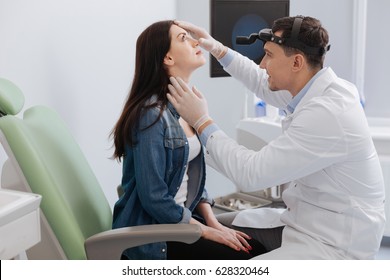 Positive otorhinolaryngologist checking nose of his patient