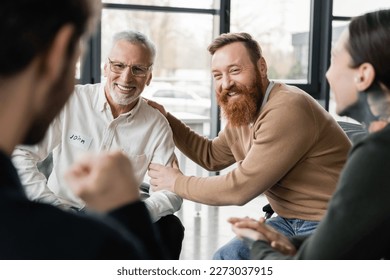 Positive people with alcohol addiction sitting in circle in rehab center - Powered by Shutterstock