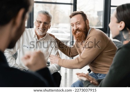 Positive people with alcohol addiction sitting in circle in rehab center