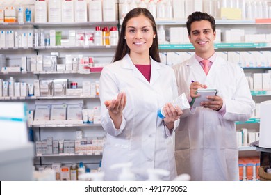 Positive Pharmacist And Pharmacy Technician Working In Drugstore