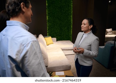 Positive Pleasant Hispanic Furniture Design Studio Manager Working With Client In Sofa Exhibition Center. Interior Design, Human Relationships, Communication, Housing Project Concept, Small Business