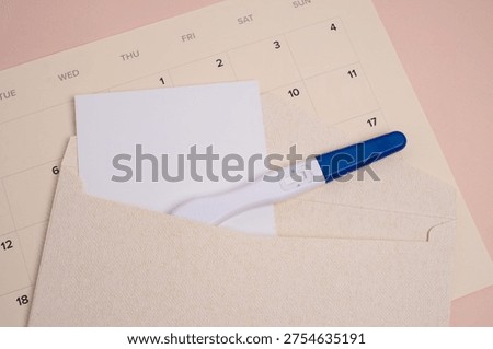 Positive pregnancy test in craft envelope on pink background. Pregnancy announcement concept. 