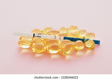 Positive Pregnancy Test And Vitamins Pills On Pink Background Close Up, Pregnancy Concept