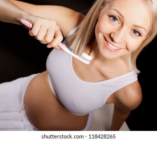 Positive pregnant blond woman  checks her teeth - Powered by Shutterstock