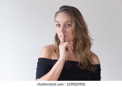 Positive Pretty Caucasian Woman Holding Finger Near Mouth. Young Female Colleague Sharing Beauty Tips. Wellness Secret Concept