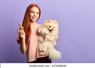 Positive Red-haired Girl Having Fun With Her Dog, Close Up Portrait, Isolated Blue Background, Studio Shot.