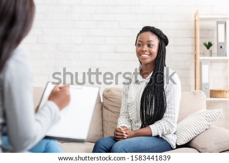 Positive results of therapy. Happy african american woman sitting at psychologist office after successful session, free space