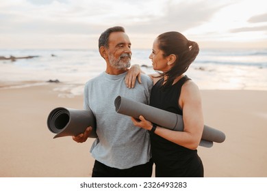 Positive senior caucasian family in sportswear with mat enjoy workout and active lifestyle on beach in morning, outdoor. Love, relationships, sports together, yoga and fit at summer - Shutterstock ID 2326493283