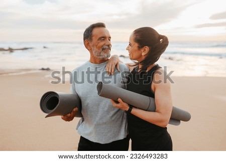Positive senior caucasian family in sportswear with mat enjoy workout and active lifestyle on beach in morning, outdoor. Love, relationships, sports together, yoga and fit at summer