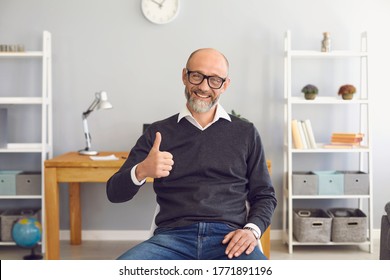 Positive senior man comminucating online, showing thumb up gesture at home. Elderly vlogger broadcasting on webcam - Powered by Shutterstock