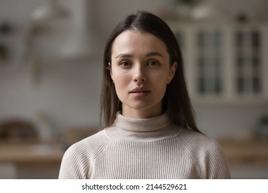 Positive serious millennial model girl home female head shot portrait. Beautiful young adult Caucasian woman looking at camera, posing in apartment. Front profile picture - Shutterstock ID 2144529621