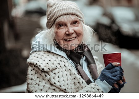 Positive smile. Portrait of a cheerful aged woman smiling to you while being in a great mood