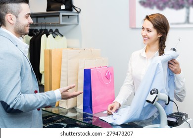 Positive Smiling Customer Paying For New Apparel At Store Counter 