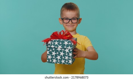 Positive smiling little toddler children boy presenting birthday gift box stretches out hands, offer wrapped present career bonus, celebrating party. Young preschool kid isolated on blue background - Powered by Shutterstock