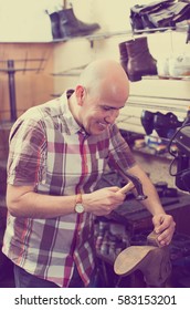 Positive Specialist Fixing Heel Taps Of Shoes On Machine