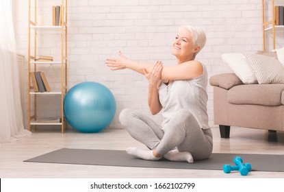 Positive sporty senior woman warming up at home, panorama, free space