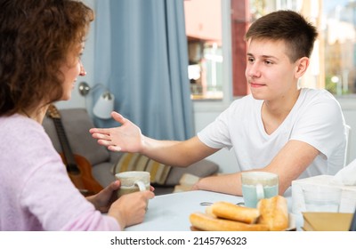 Positive Teen Boy With Mother Enjoying Time At Home, Having Friendly Conversation