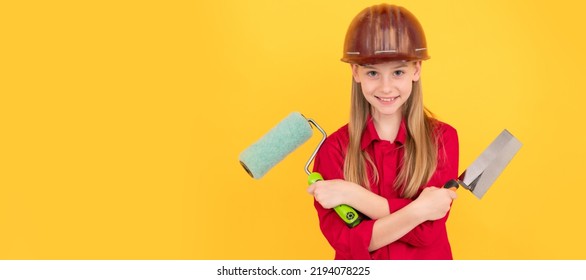 Positive Teen Child In Builder Hard Hat With Paint Roller And Spatula On Yellow Wall. Child Builder In Helmet Horizontal Poster Design. Banner Header, Copy Space.