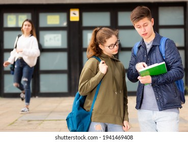 Positive Teenage Friends Discuss Past Lessons On The Street Near College Building