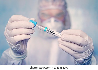Positive Test For Antibodies To Coronavirus. Checking The Population For Immunity To Covid 19. A Test Tube With A Blood Test In The Hands Of A Doctor Against The Background Of Laboratory Research.