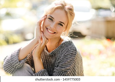 Positive Woman With Charming Smile Looks Into Camera. Girl In Gray Outfit Posing On Street In Spring