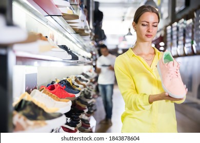 Positive Woman Choosing Sneakers In Streetwear Store