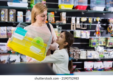 Positive Woman With Small Girl Shopping In Pet Store, Buying Cage For Small Animal